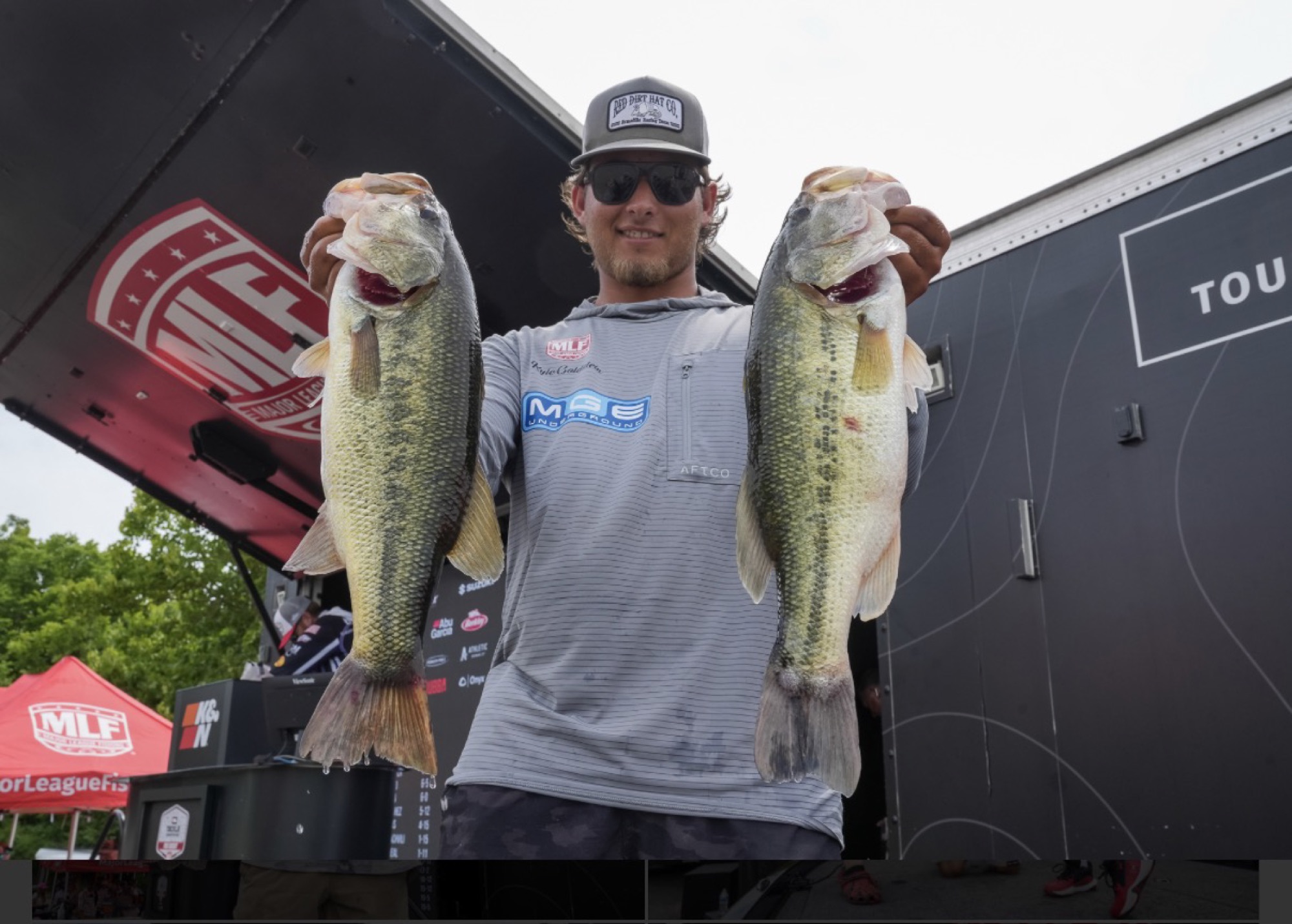 Kyle Goldstein at a Major League Fishing weigh-in with two largemouth bass