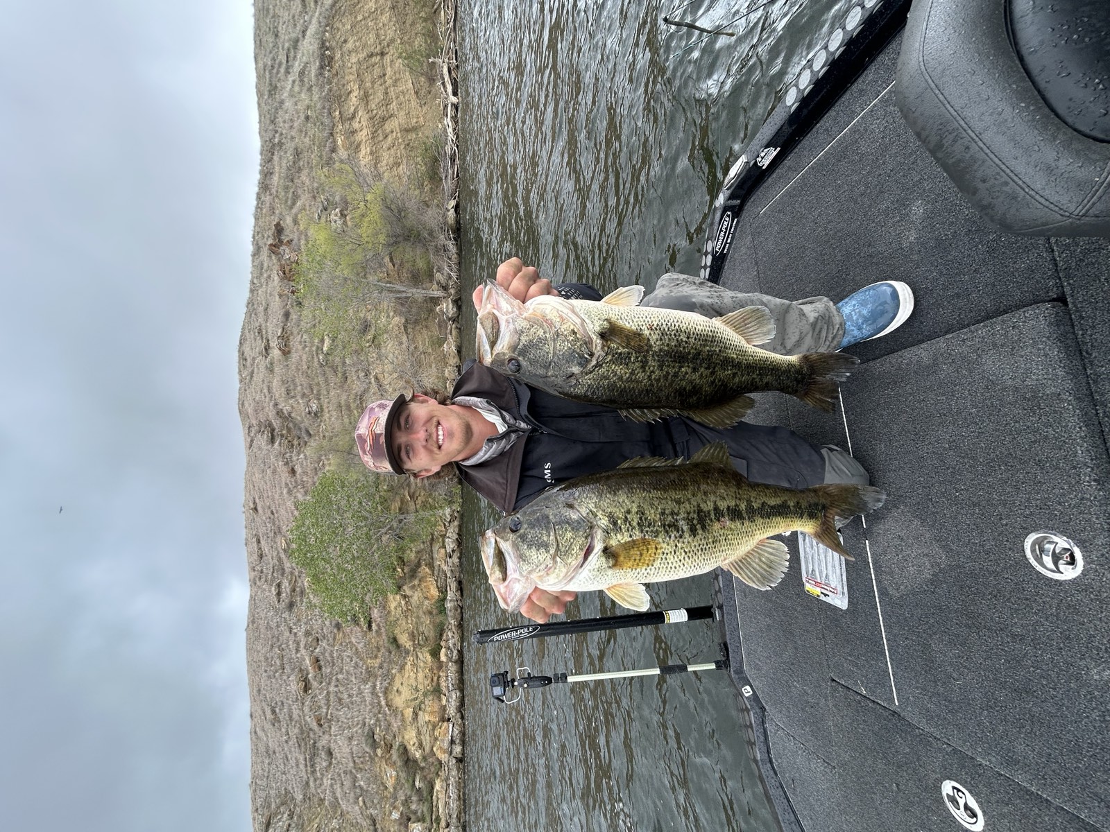 Kyle Goldstein on the boat holding two large largemouth bass on Lake Nacimiento