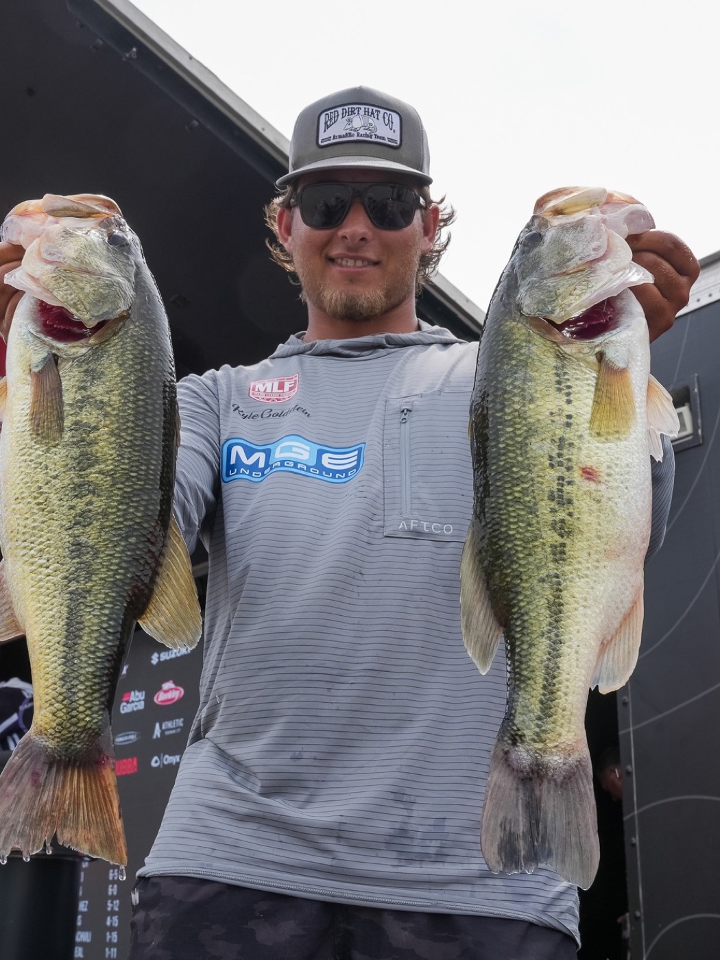 Kyle Goldstein at a Major League Fishing weigh-in holding two large largemouth bass